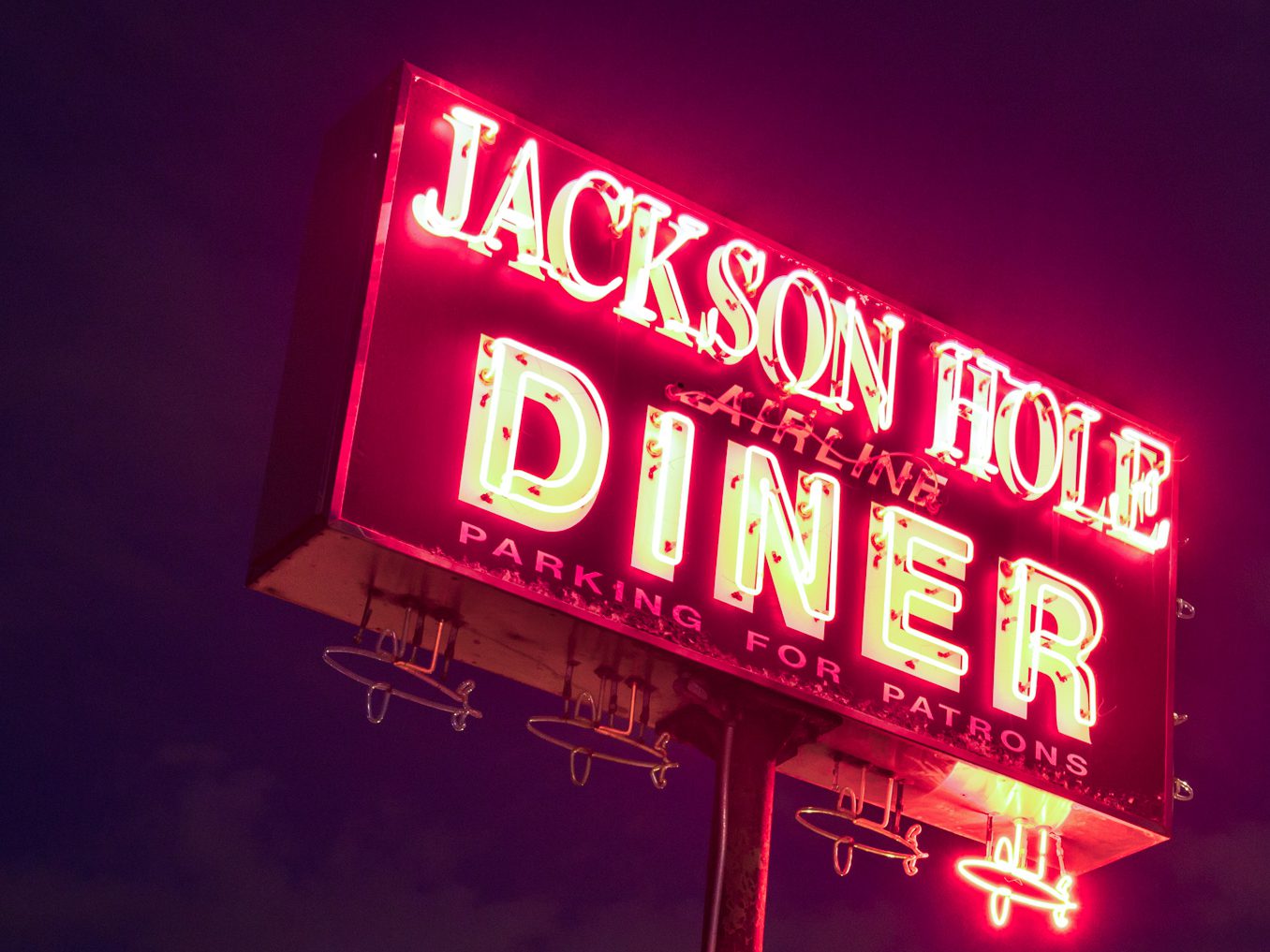 Neon sign for Jackson Hole Diner glowing at night.