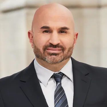 Professional man in a suit and tie smiling.